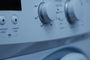 Detalle del panel de control de una lavadora doméstica con diales de temperatura y programas.