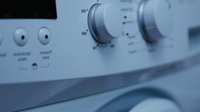 Detalle del panel de control de una lavadora doméstica con diales de temperatura y programas.