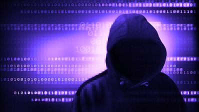 Silueta de una persona con capucha frente a un fondo de código binario iluminado en tonos púrpuras.