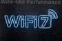 Logotipo de WiFi 7 con iluminación de neón azul sobre una superficie metálica oscura texturizada.