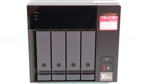 Vista frontal de un servidor NAS QNAP TS-473A con cuatro bahías para discos duros, botones de control y puertos de conexión rápidos.