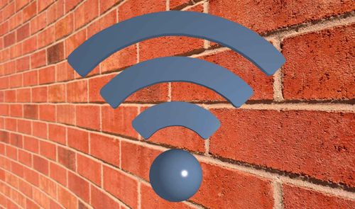 Icono de señal Wi-Fi de color azul sobre una pared de ladrillo rojo.