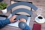 Persona trabajando con un ordenador portátil en una mesa de madera con un icono de señal Wi-Fi superpuesto.