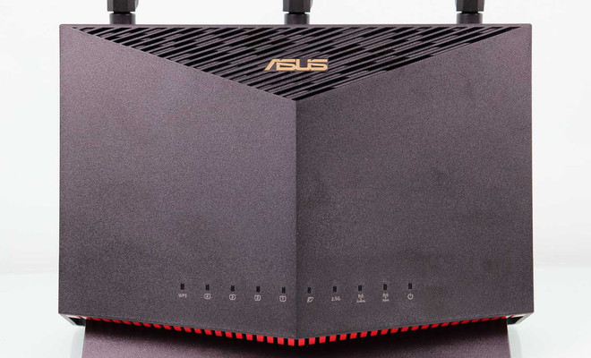 Frontal del router ASUS RT-AX86U en posición vertical con indicadores LED y rejilla de ventilación superior.