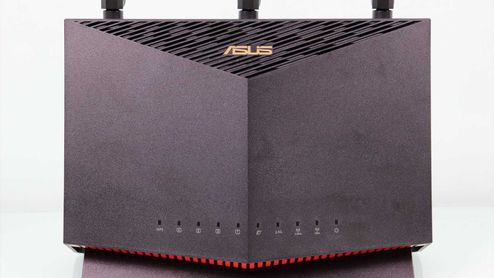 Frontal del router ASUS RT-AX86U en posición vertical con indicadores LED y rejilla de ventilación superior.