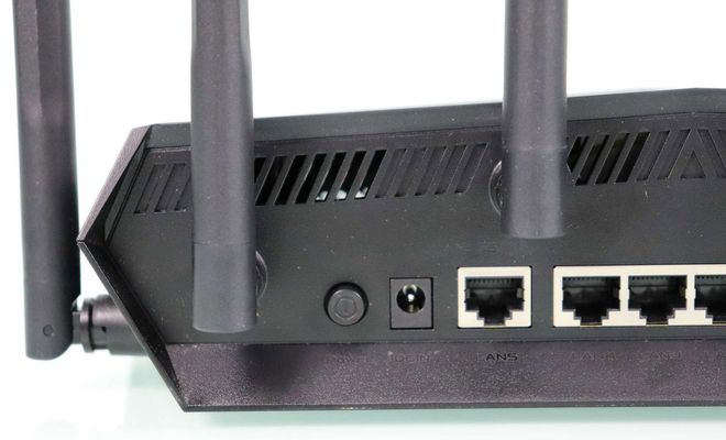 Detalle de los puertos traseros y antenas del router ASUS TUF-AX6000 sobre un fondo blanco.