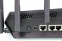 Detalle de los puertos traseros y antenas del router ASUS TUF-AX6000 sobre un fondo blanco.