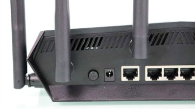 Detalle de los puertos traseros y antenas del router ASUS TUF-AX6000 sobre un fondo blanco.