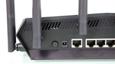 Detalle de los puertos traseros y antenas del router ASUS TUF-AX6000 sobre un fondo blanco.