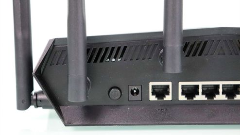 Detalle de los puertos traseros y antenas del router ASUS TUF-AX6000 sobre un fondo blanco.