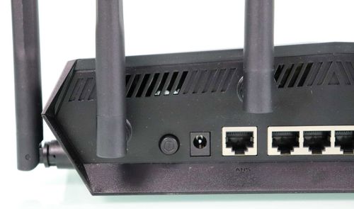 Detalle de los puertos traseros y antenas del router ASUS TUF-AX6000 sobre un fondo blanco.