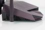 Vista lateral del router TUF-AX6000 con rejillas de ventilación y antenas externas en color oscuro.