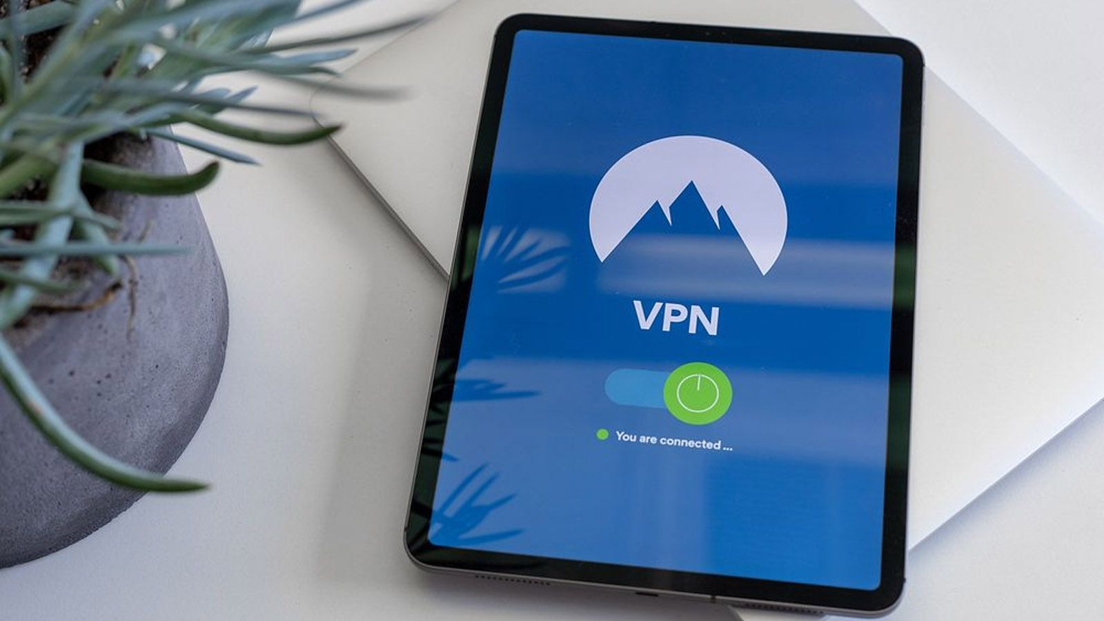 Interfaz de una aplicación VPN activa en la pantalla de una tableta situada sobre una mesa.
